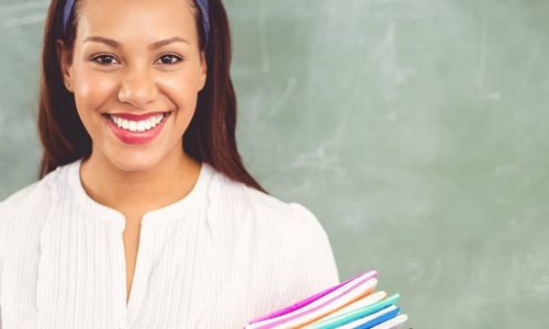 Lehrerin mit Unterlagen vor Tafel für Jobs, Ausbildung und Berufseinstieg in Bildung und Pädagogik