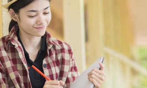 Studentin schreibt Notizen für Jobs und Berufseinstieg in Geisteswissenschaften, Sprachwissenschaften und Gesellschaft
