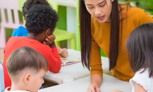 Betreuerin unterstützt Kinder beim Lernen für Nebenjobs in Nachhilfe und Unterricht