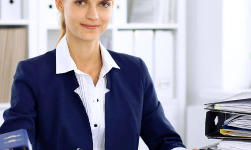 Kaufmännische Mitarbeiterin mit Unterlagen und Taschenrechner für Jobs, Ausbildung und Karriere in Wirtschaft und Sekretariat